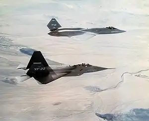 Two different jet aircraft in flight towards right of screen.