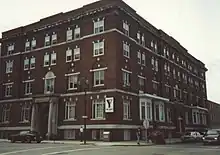 Exterior of a five-storey red-brick building with white trim around the windows and doors