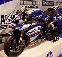 Blue and white streamlined motorcycle with racing tires is an exhibition setting