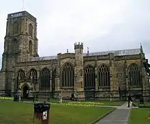 Stone building with arched windows and square tower.