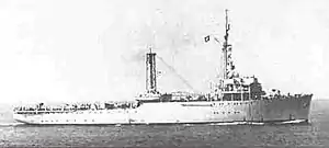 A ship at sea with mountains in the background