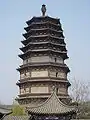 A wide, octagonal pagoda. It has four tall, functional floors made of brick, and an additional five, short, purely decorative floors made of wood. Each floor is separated by an eave, and the top five floor's eaves look as if they were simply stacked right on top of one another.