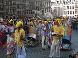 Colourfully-dressed participants playing musical instruments on the Grand-Place