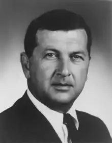 Portrait of a man in his 40s wearing a dark suit, facing the camera