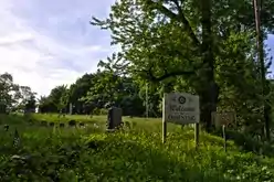 A wooden sign "Welcome to Ossining" and a metal sign for Sparta Cemetery