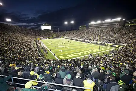 Nighttime panorama of a full stadium during a football game.