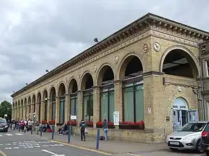 A light brick railway station with grand arches in Cambridge