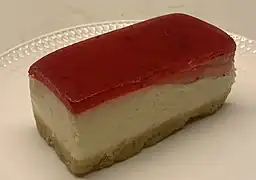 three-layered dessert.  The bottom is a crumb crust, the middle is a thick layer of cheesecake, and the top is a thin, solid layer of bright red gelatin