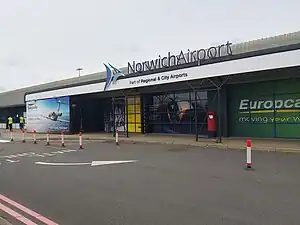 The front of Norwich Airport - a single-storey building with "Norwich Airport" written on the front