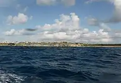 To the south west of Foul Bay, Oliver's cave, Ocean City is topped by a precarious house, Centre of picture. Little Bay is right of Centre. Part of Foul Bay is extreme right. Viewed from The Fathom.