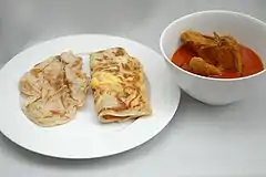 Roti prata (left) and roti telur (centre) with a side order of chicken curry