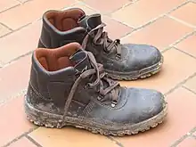 Muddy leather shoes on tile floor