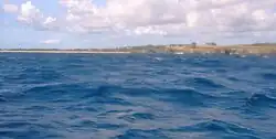 The small beach 500 m north east of Long Beach is practicable for a diver to swim ashore and get up the low cliffs at the left end.